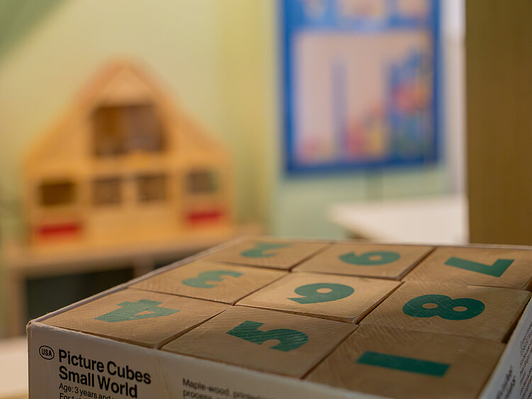 Mehrere Spielwürfel aus Holz liegen auf einem Tisch.