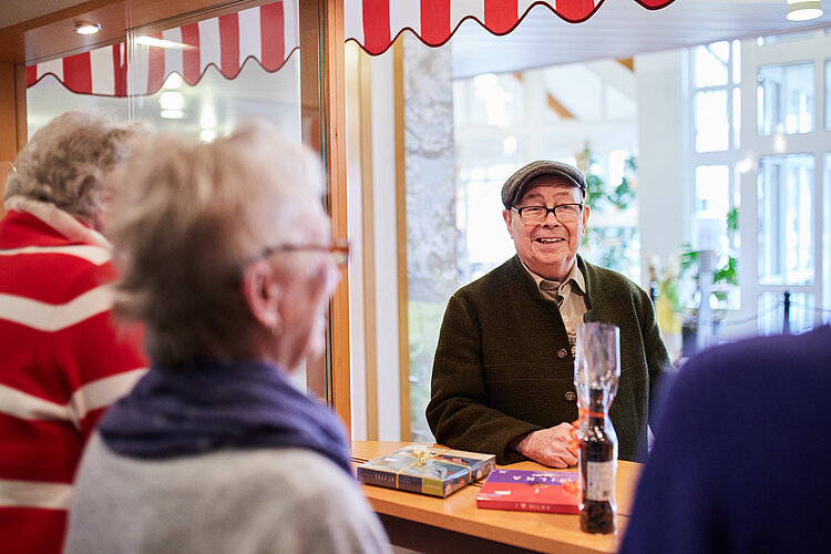 Lachender Bewohner am hauseigenen Kiosk