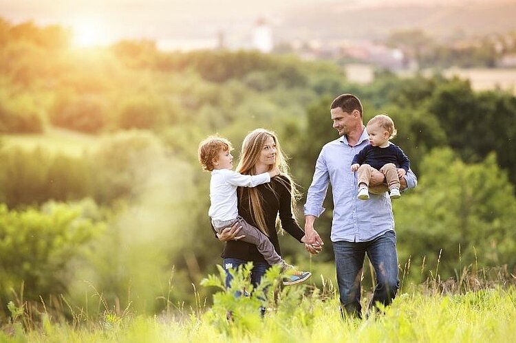 Eine Familie mit zwei Kindern ist gemeinsam in der Natur unterwegs.