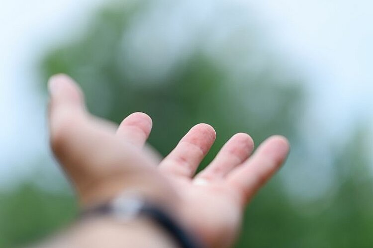 Eine ausgestreckte Hand mit geöffneter Handfläche.