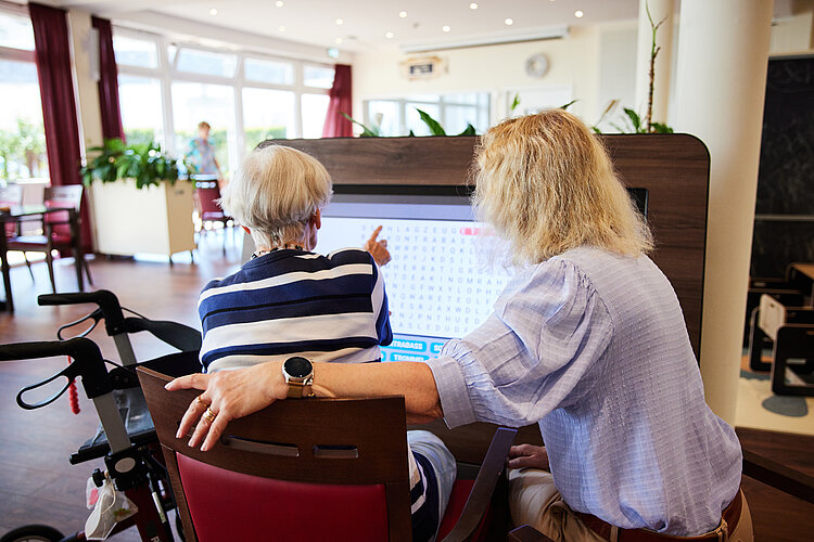 Pflegekraft mit Patientin im Rollstuhl