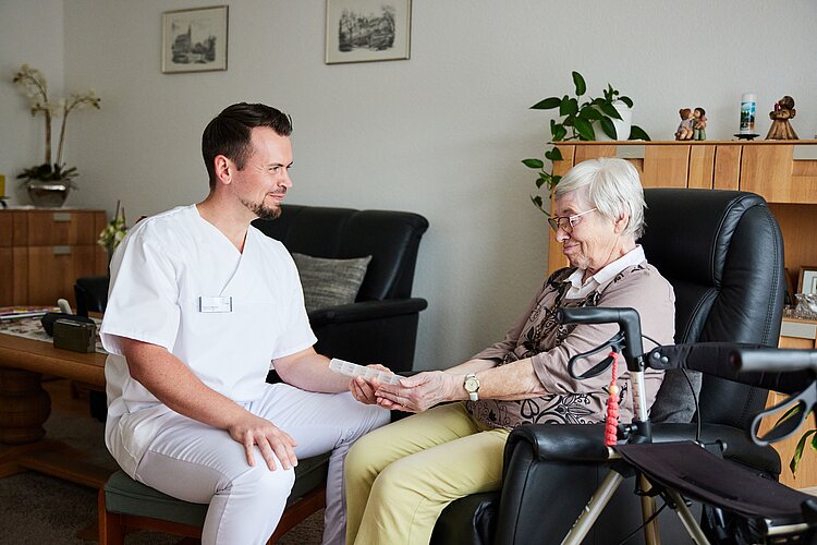 Pfleger betreuut Bewohnerin