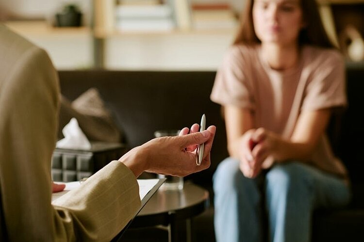 Zwei Frauen sitzen sich in einem persönlichen Gespräch gegenüber.